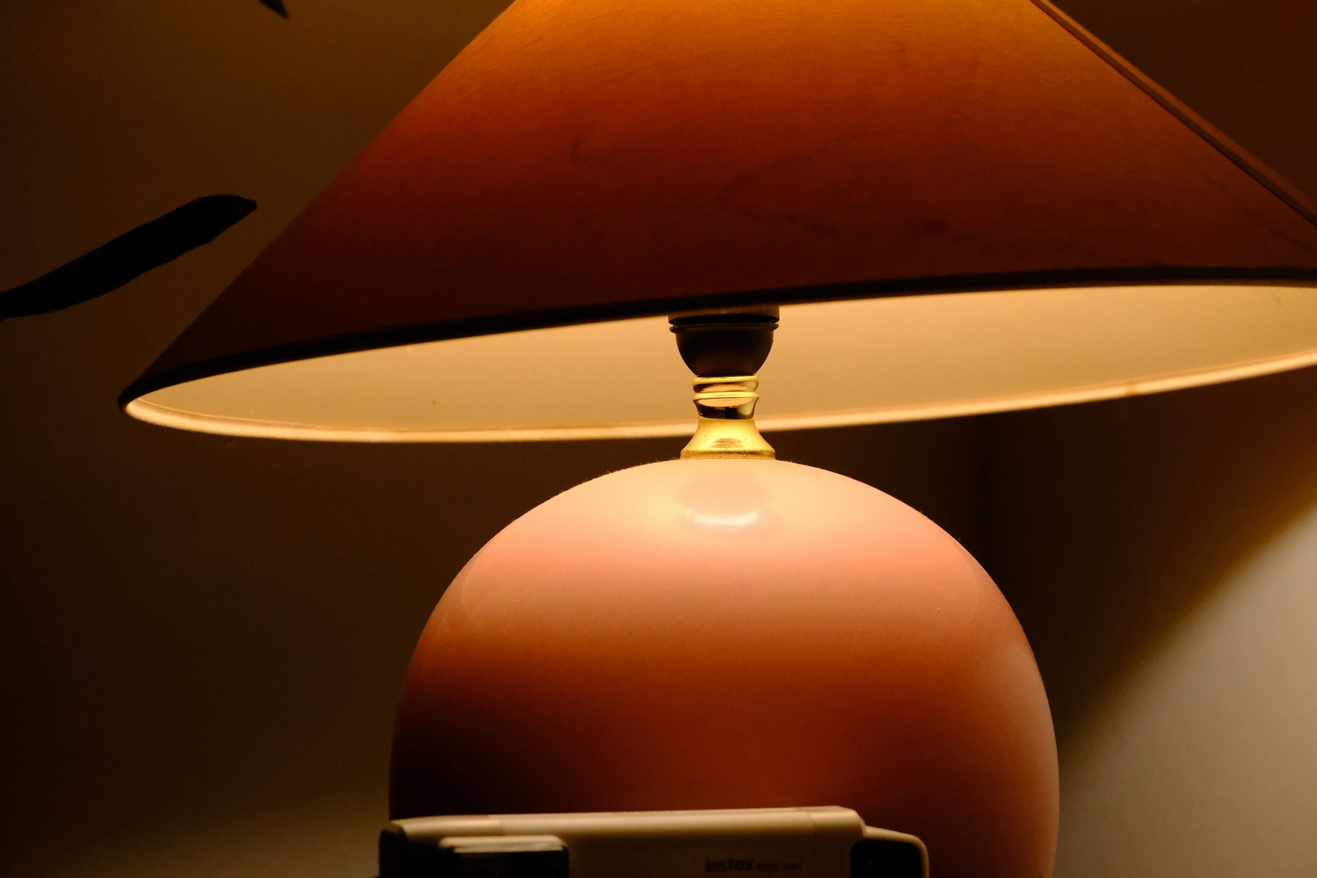 A glazed ceramic table lamp with a warm, glowing shade